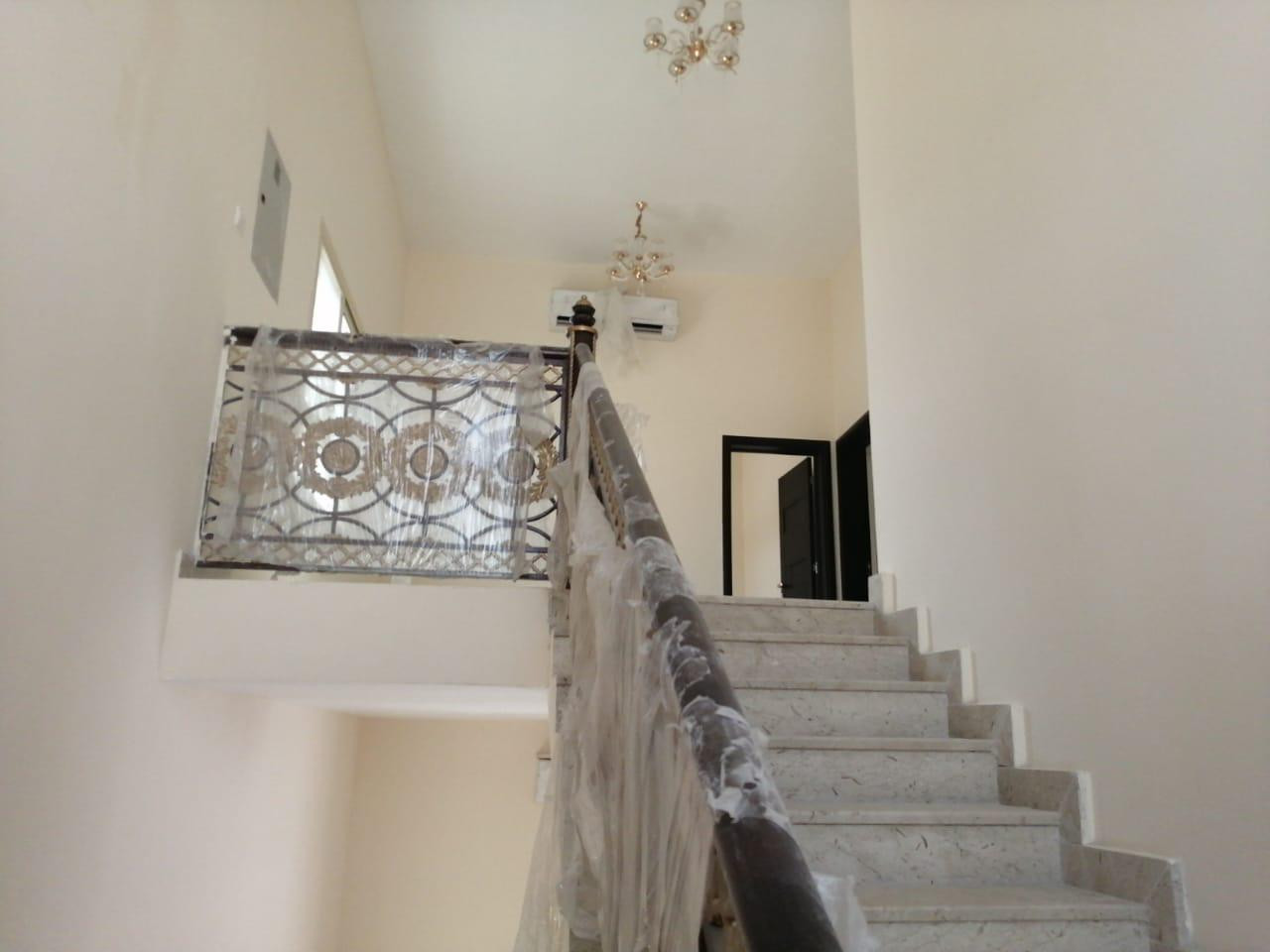 Two-story villa for rent in Al Ghafia, prime location on a main street, 5 master bedrooms and a laundry room