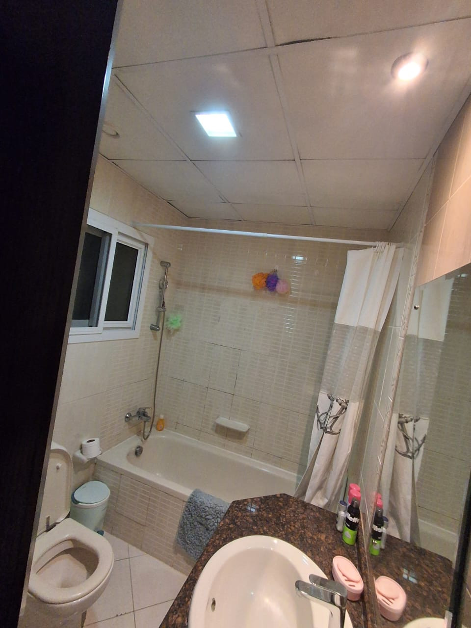 Master bedroom with private bathroom, sofa, and TV