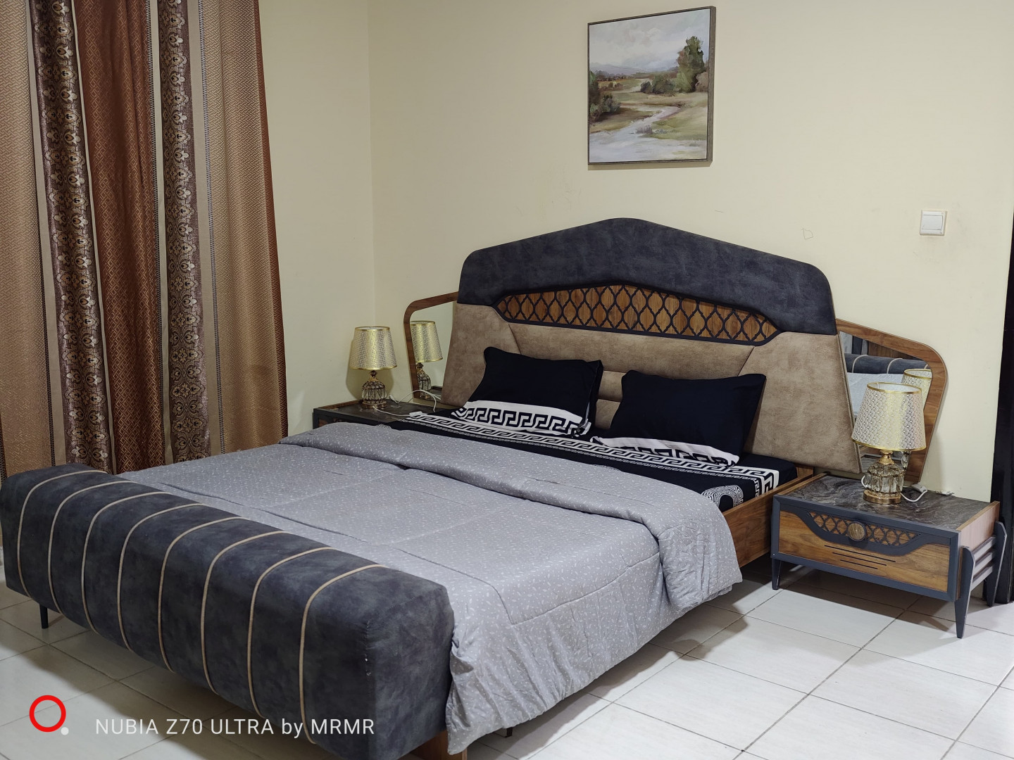 One bedroom and living room furnished with hotel furniture