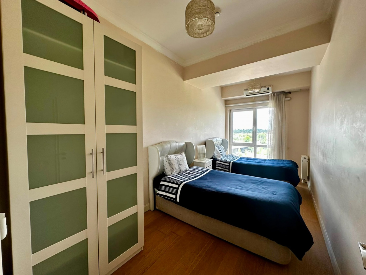 Two bedrooms and a living room with a view of the highway.