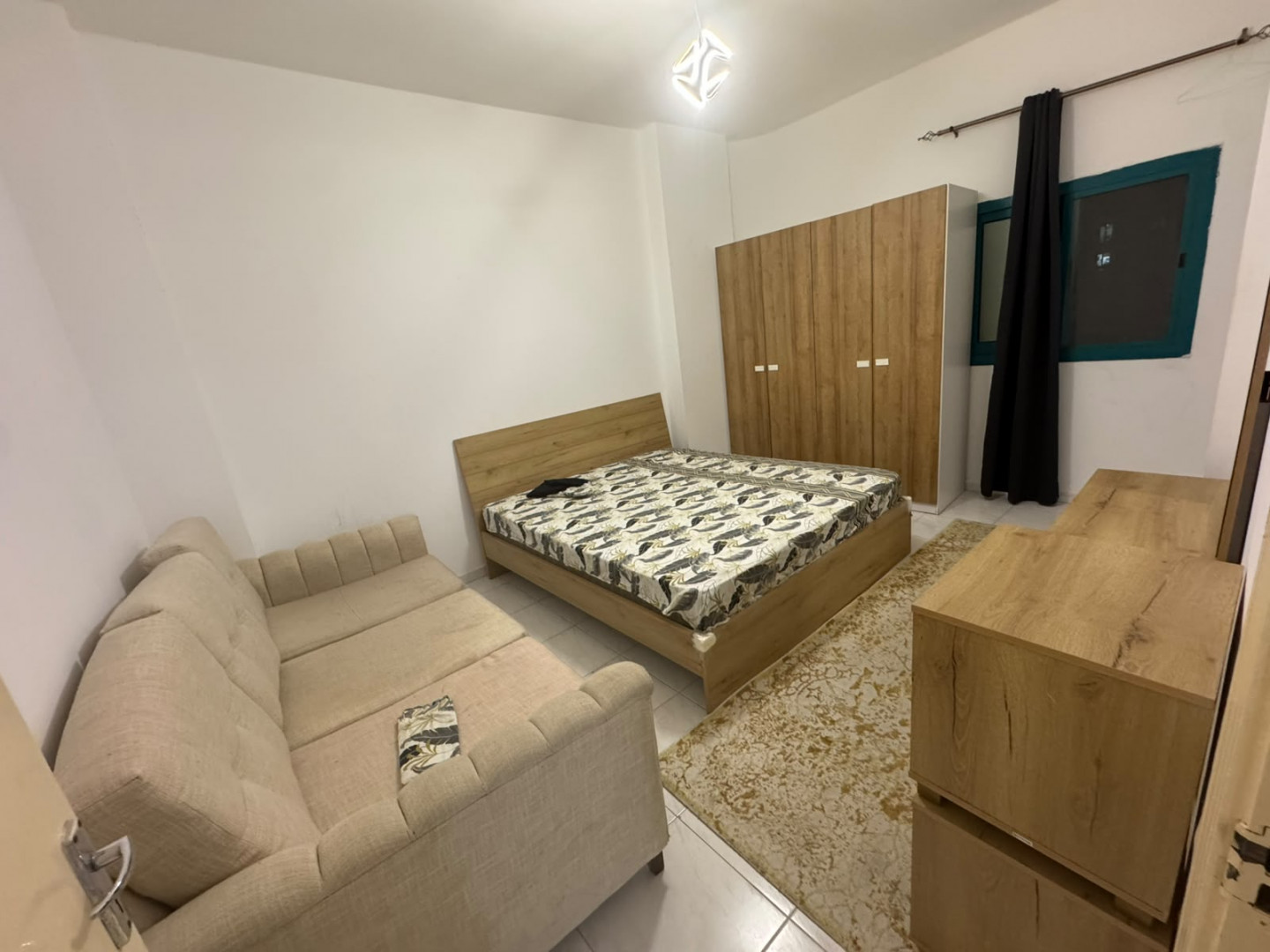Two bedrooms and a living room, furnished with clean furniture and a balcony.