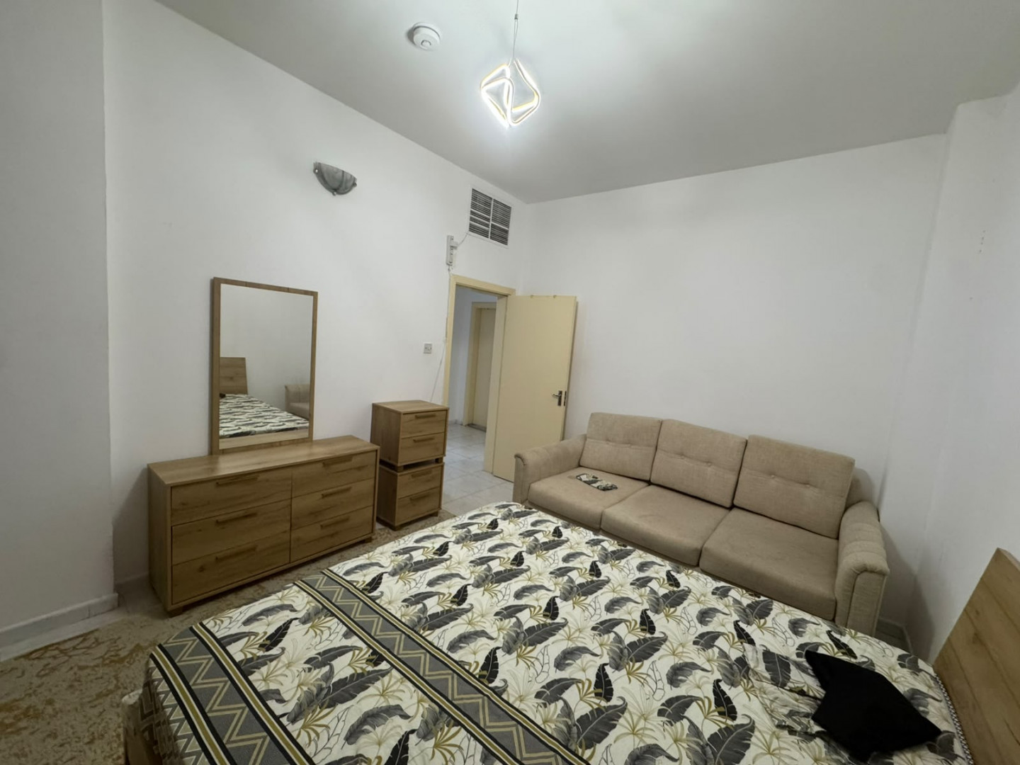 Two bedrooms and a living room, furnished with clean furniture and a balcony.