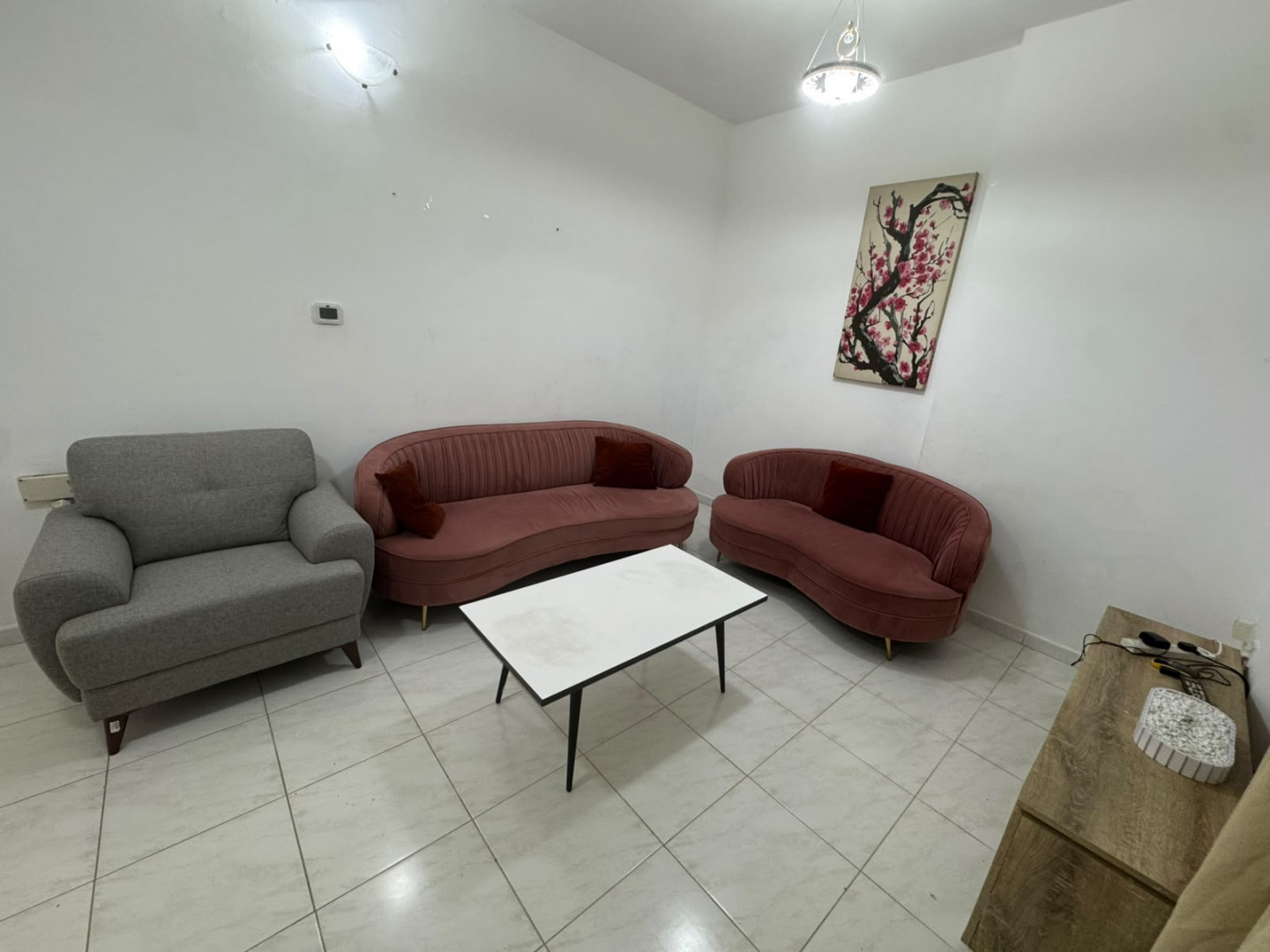 Two bedrooms and a living room, furnished with clean furniture and a balcony.
